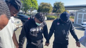 Najee Harris joins a prayer circle outside GRIP Souper Center in Richmond in 2021. (Photo credit: GRIP)